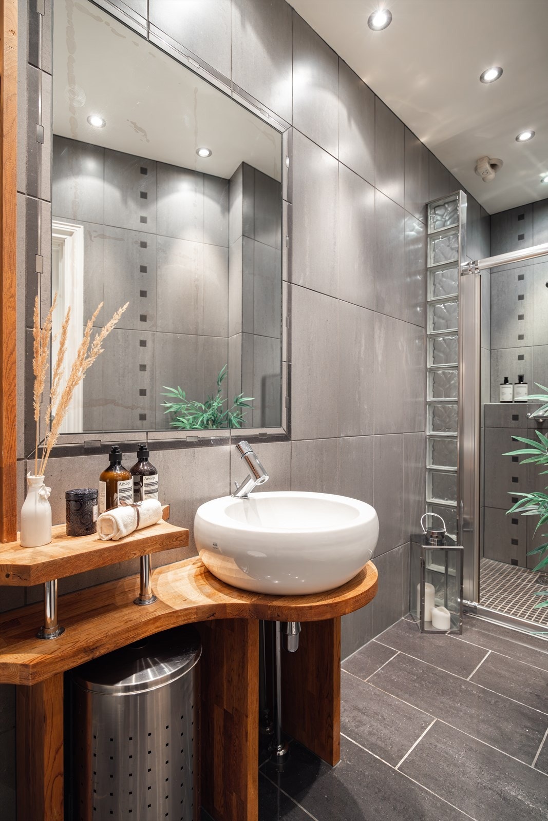 Badet er innredet med skålservant, speil, veggmontert toalett og dusjnisje. Galleribilde