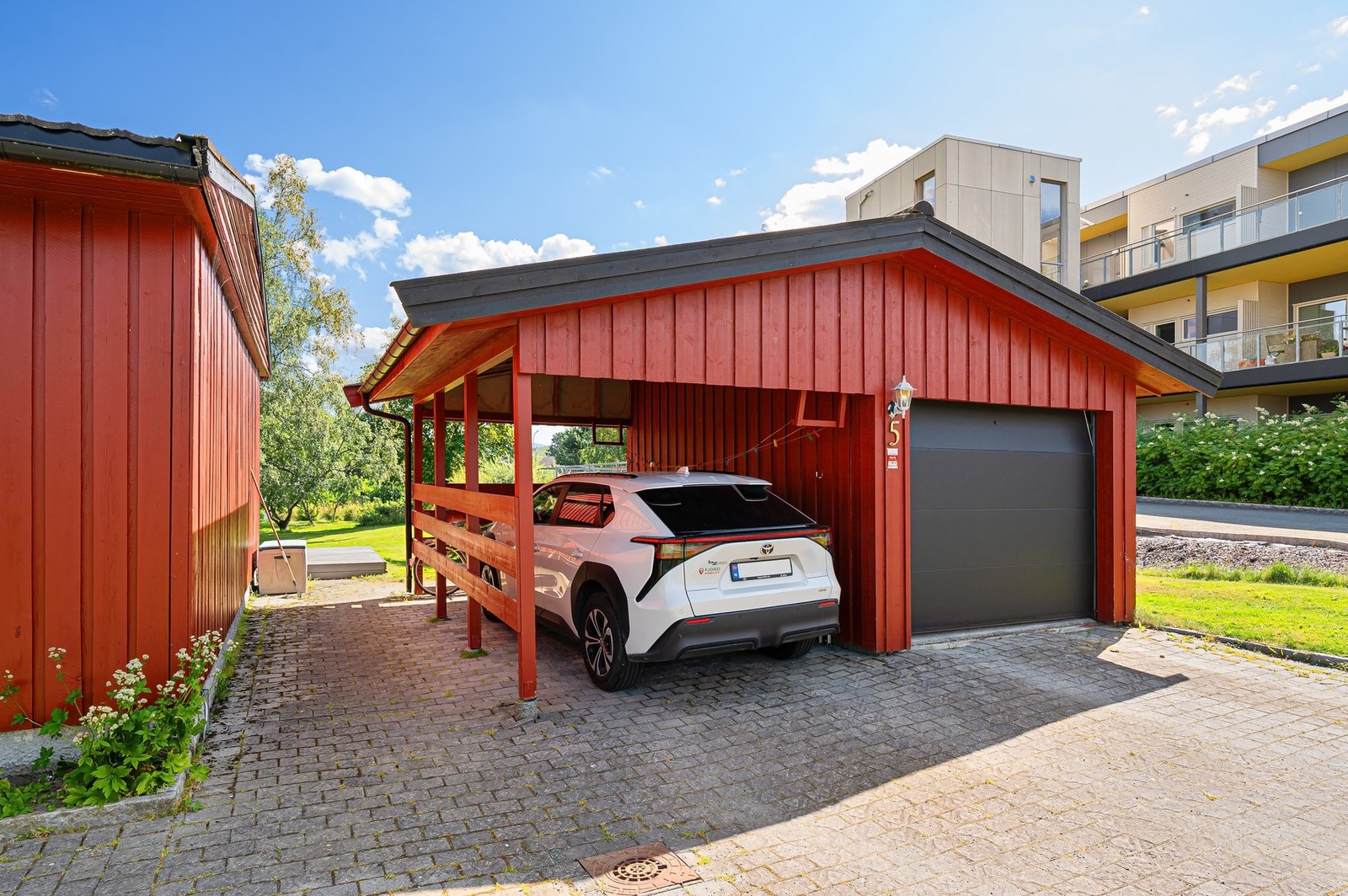Parkering i garasje og i carport. Det er også flere oppstillingsplasser på egen tomt. Galleribilde