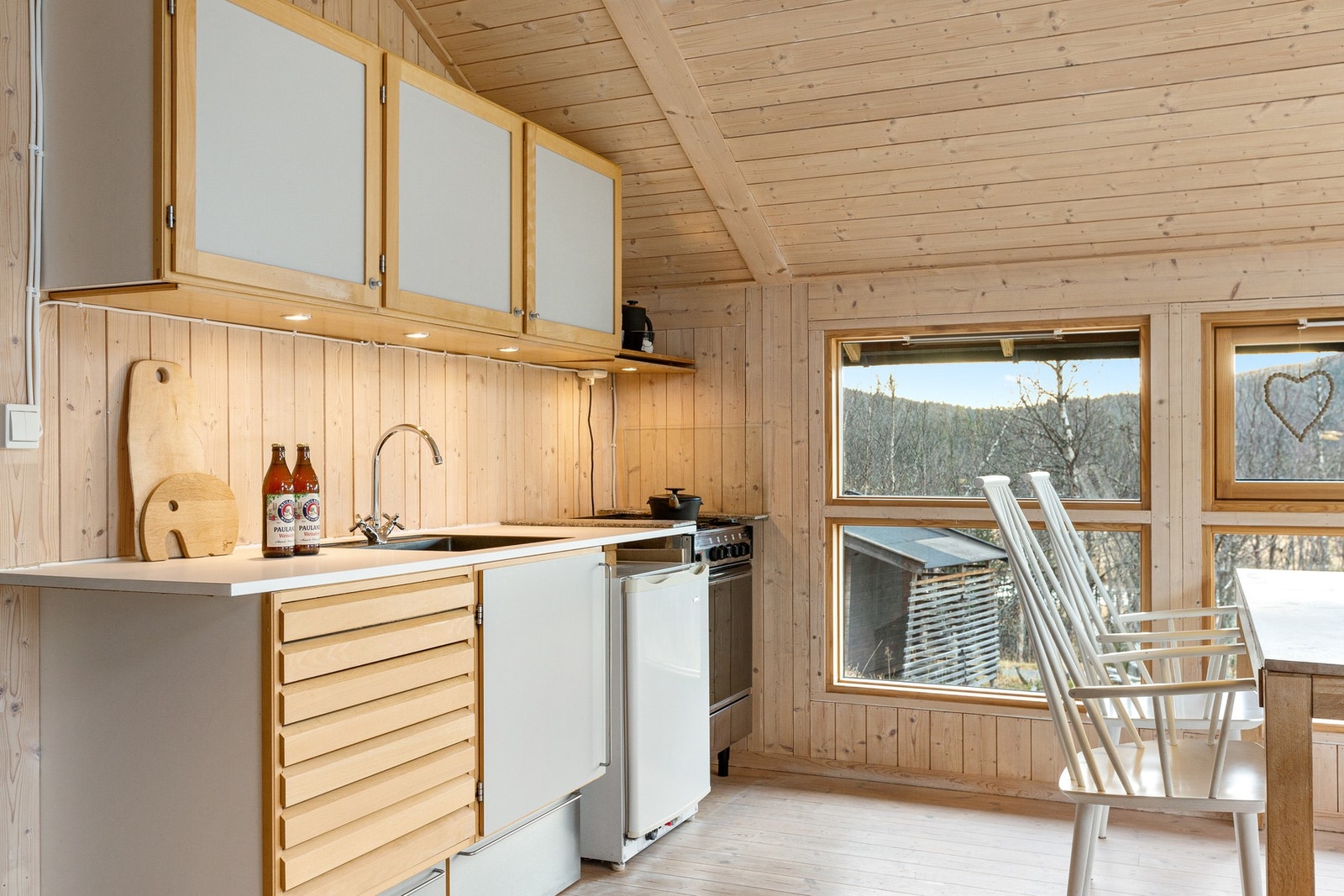 Kjøkkeninnredning med glatte fronter og laminat benkeplate. Galleribilde