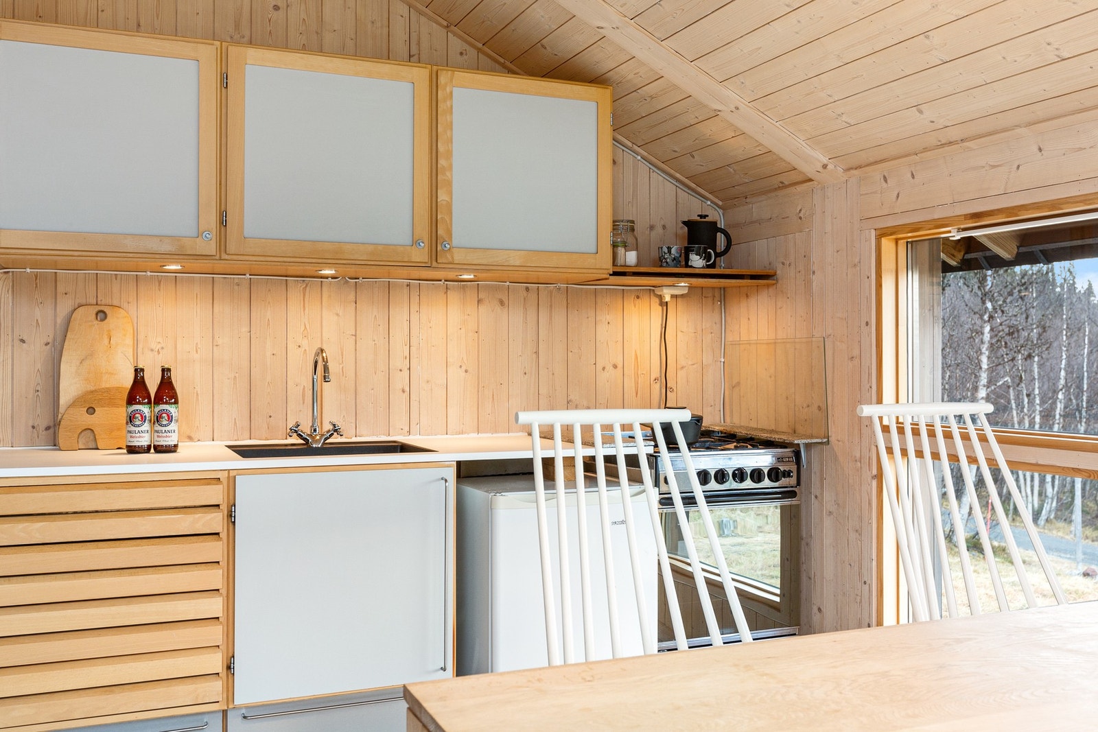 Vaskekum i laminat benkeplate, og frittstående hvitevarer som komfyr og kjøleskap. Galleribilde