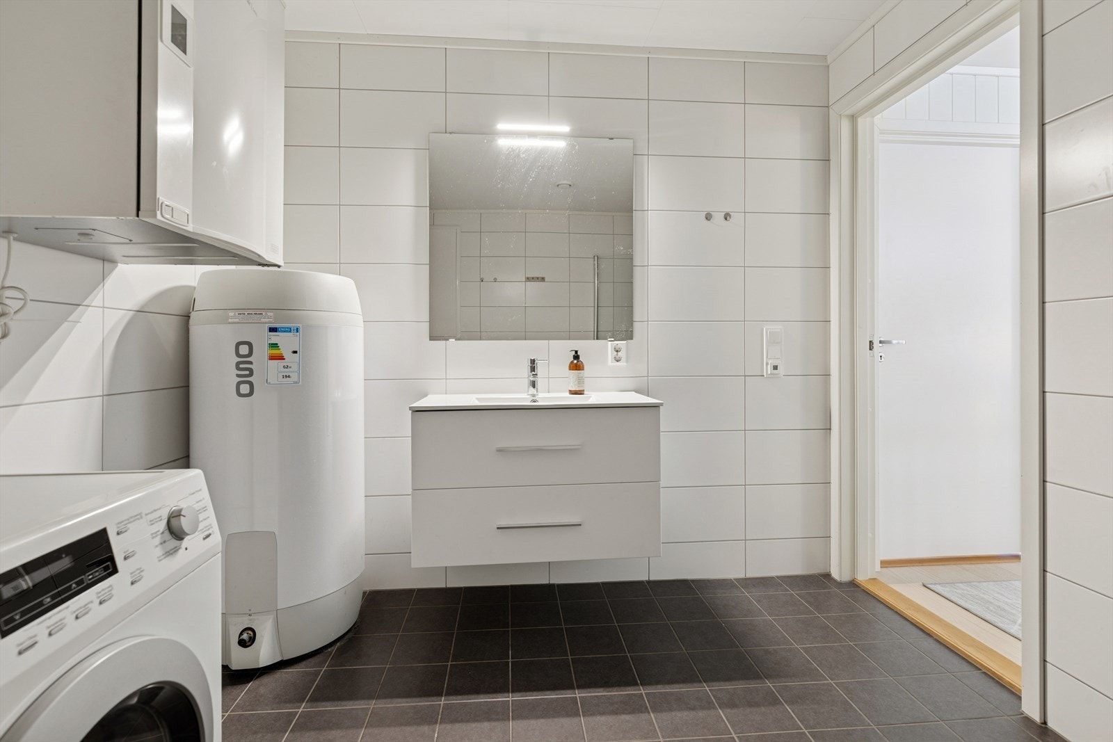 Flislagt bad med lyse overflater som gir et rent og tidløst uttrykk. Galleribilde