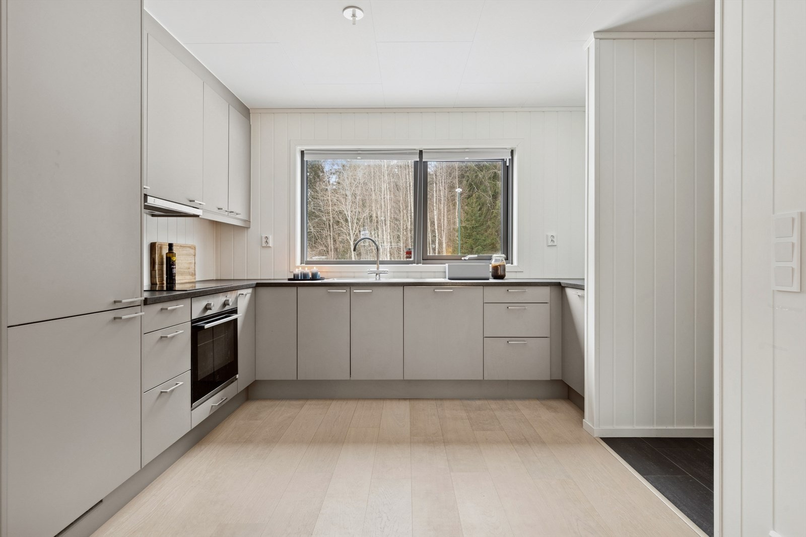 Moderne og lyst kjøkken med rikelig skap- og benkeplass. Hyggelig utsyn fra kjøkkenvindu. Galleribilde