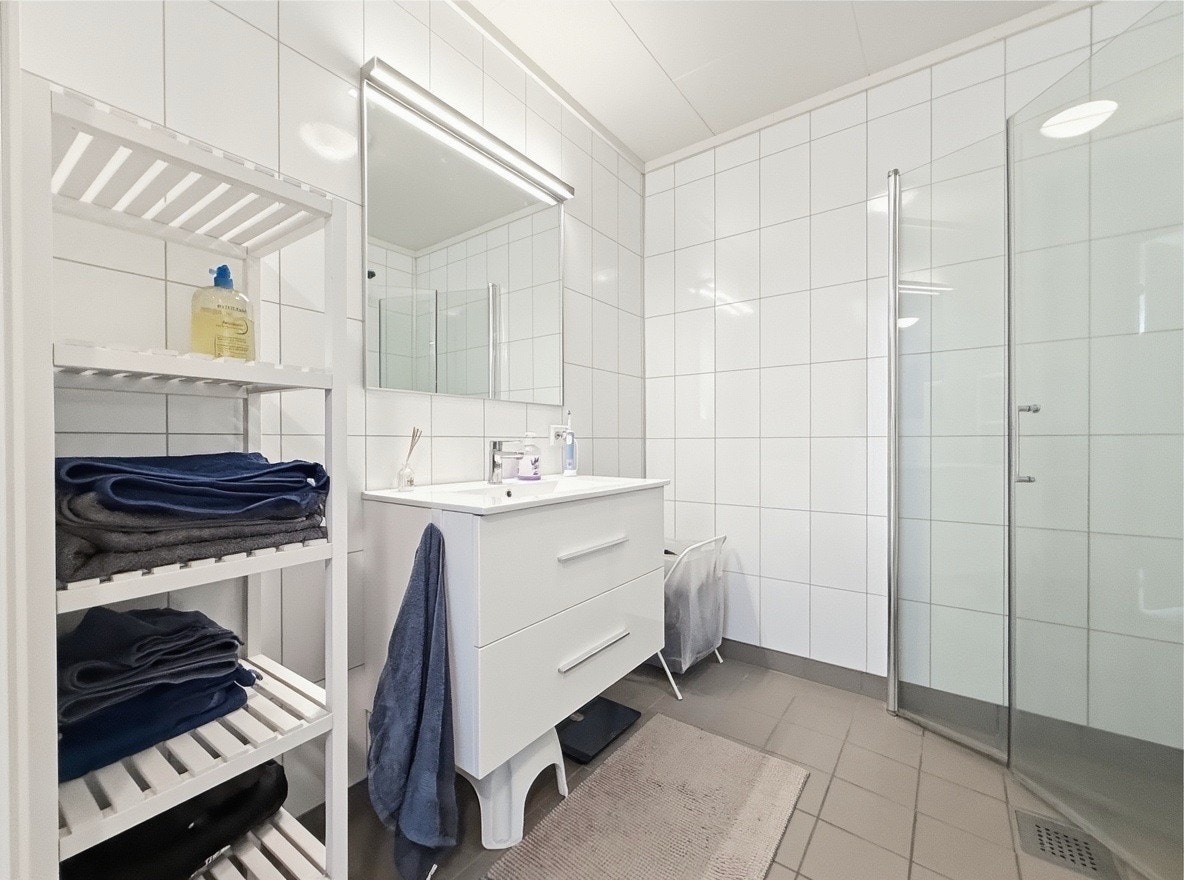 Flislagt bad med moderne innredning, dusjhjørne og oppbevaring Galleribilde