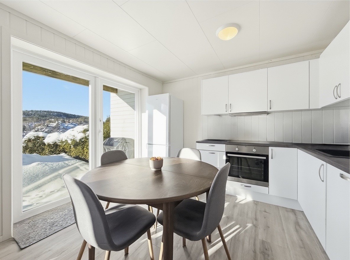 Koselig spiseplass i tilknytning til det moderne kjøkkenet og terrassedøren Galleribilde