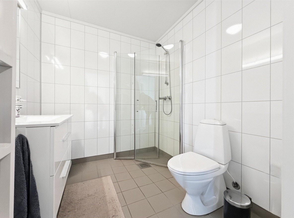 Badet har toalett og romslig dusj med glassvegger Galleribilde
