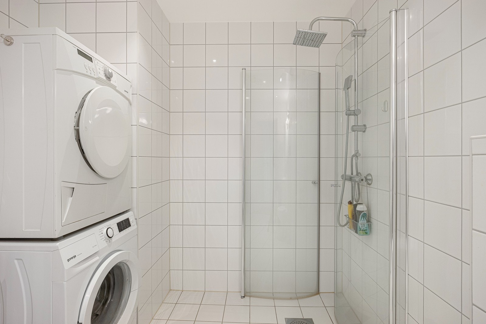 Innerst i rommet er det regnfallsdusj med innfellbare dører i glass. Det er avsatt plass til vaskemaskin og tørketrommel i søyleløsning. Galleribilde
