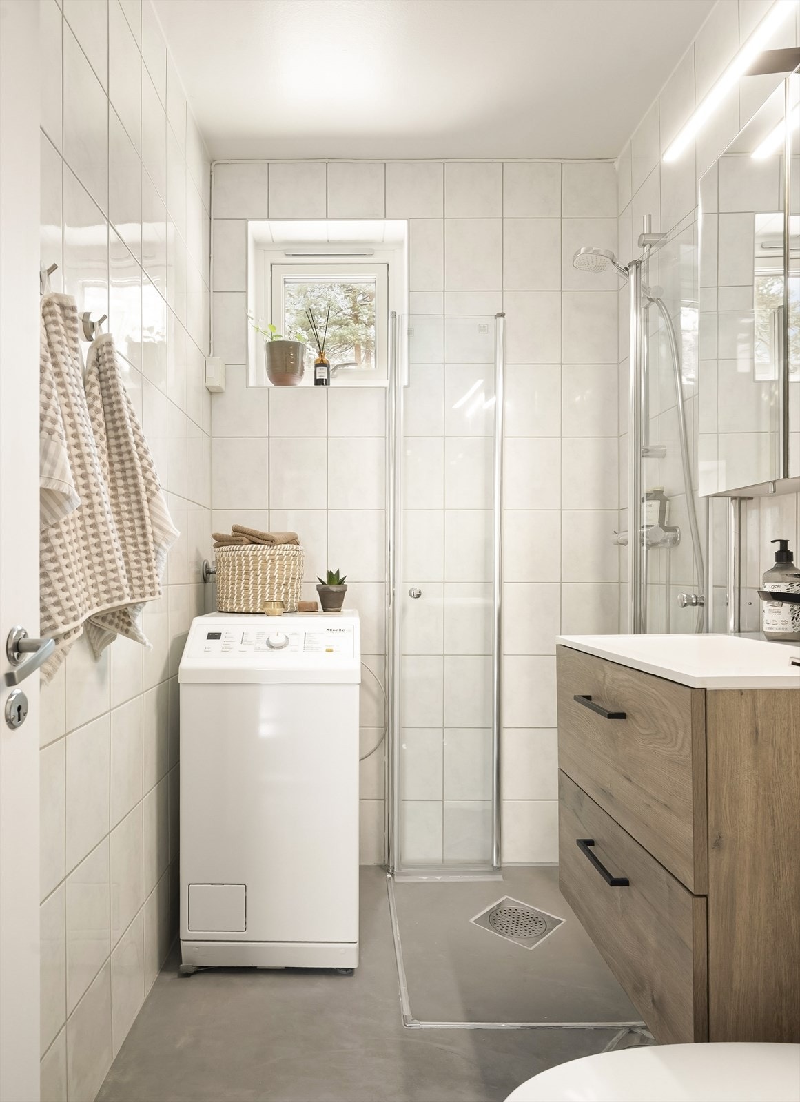 Her er det servantinnredning, dusjhjørne med glassdører og opplegg for vaskemaskin. Galleribilde