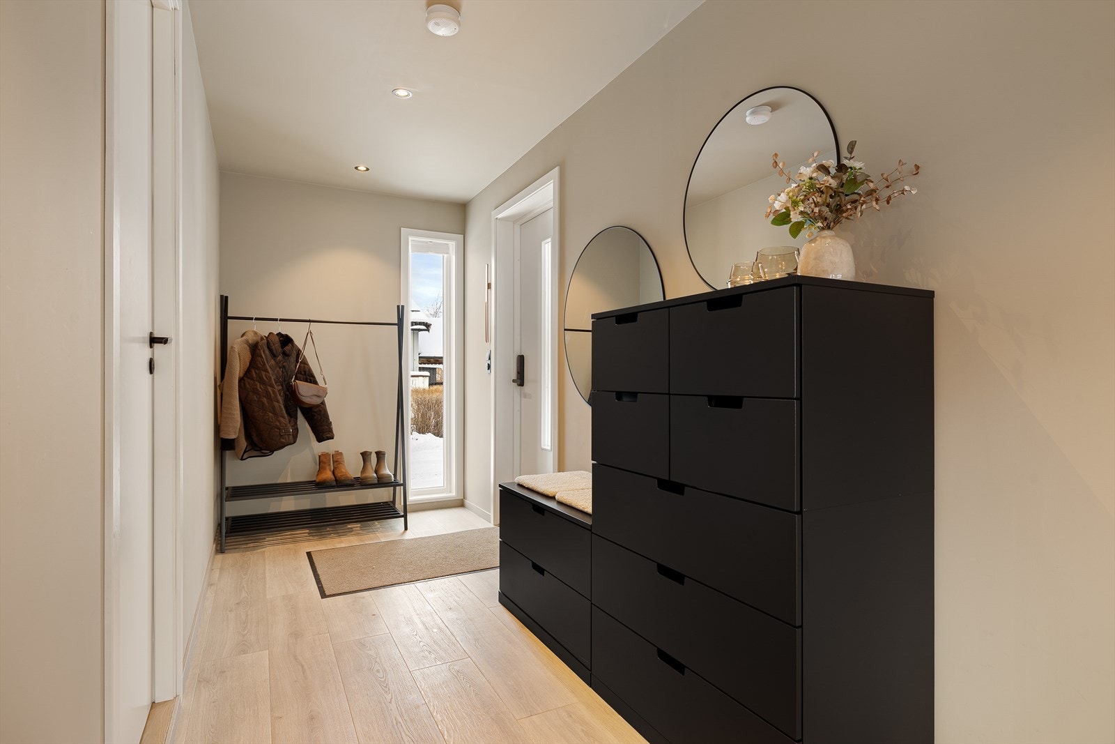 Innbydende og delikat entré med gode muligheter for oppbevaring av yttertøy. Galleribilde