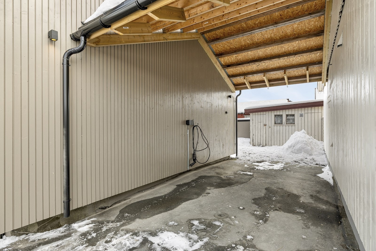 Carport med overbygg som gir værbeskyttet parkering. Galleribilde