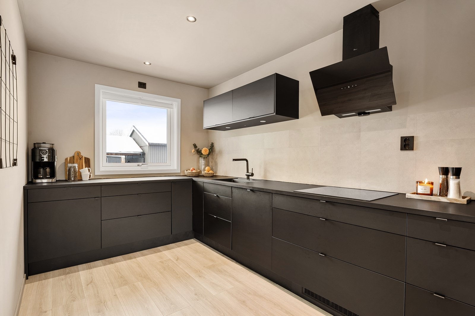 Lekkert Epoq-kjøkken fra 2022 hvor de sorte frontene viderefører boligens gjennomgående detaljer. Galleribilde