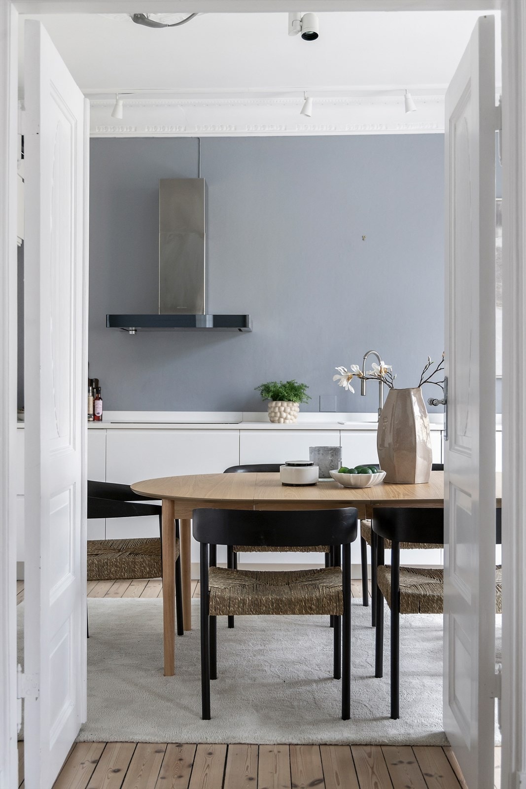 Kjøkkenet nås gjennom doble fløydører - en elegant løsning som skaper en åpen og sosial forbindelse til stuen, samtidig som rommet kan skjermes ved behov. Galleribilde