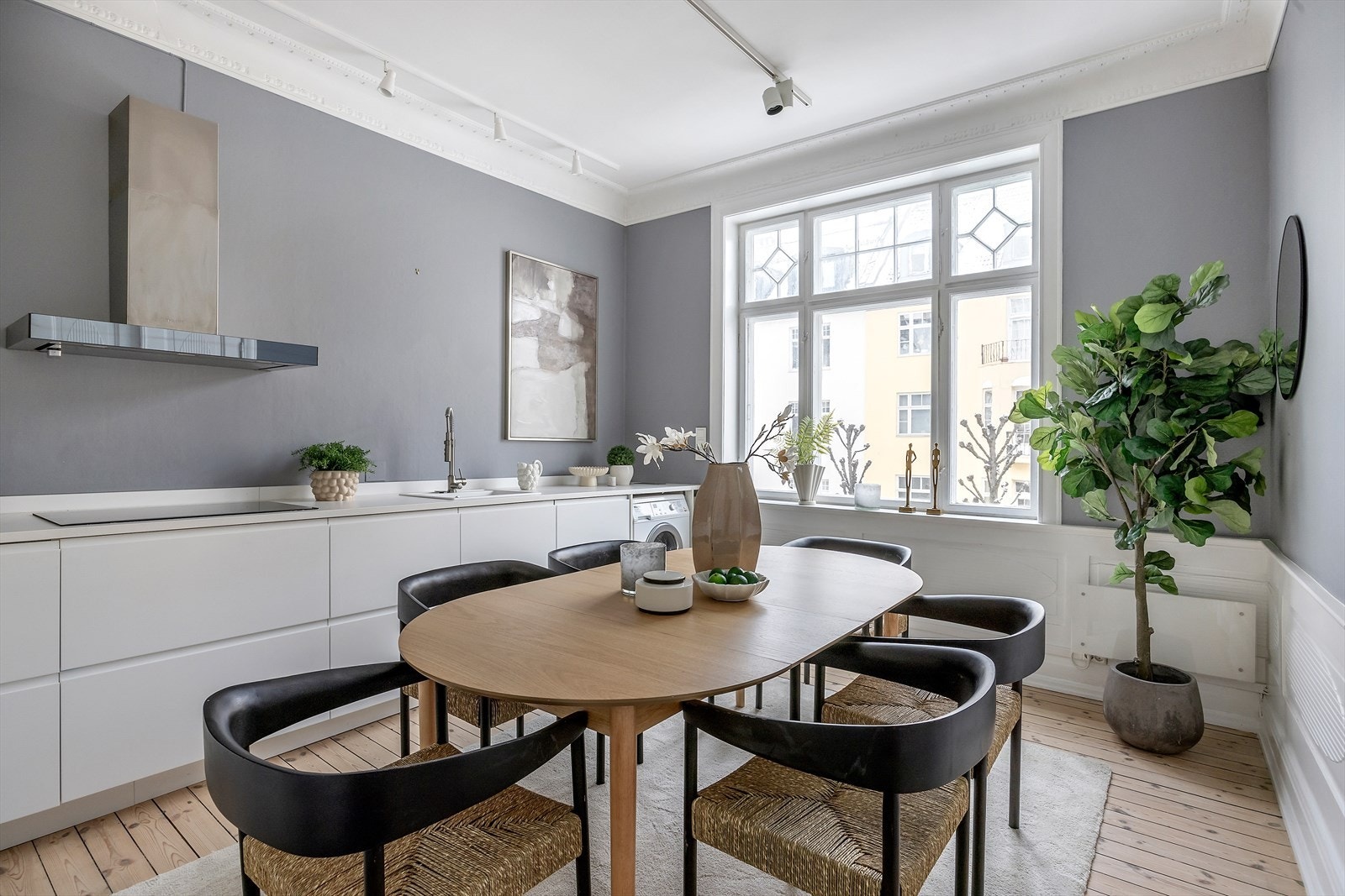 Kjøkkenet er svært praktisk utformet med skap og hyller fra gulv til tak, gode arbeidsflater og plass til en sosial spisegruppe - et naturlig samlingspunkt for familie og gjester. Galleribilde