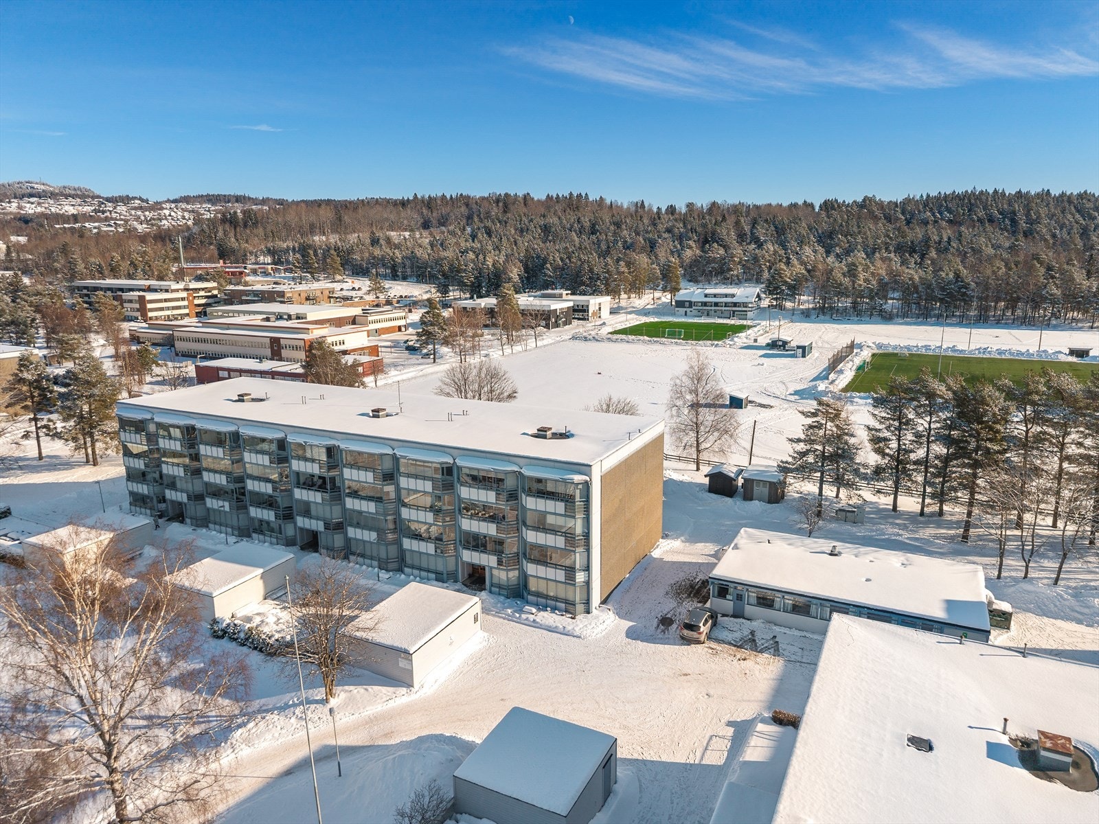 Like bak blokka ligger Tranby ungdomsskole, Hallingstad barneskole, Tranby idrettspark og Extra-butikk. Galleribilde