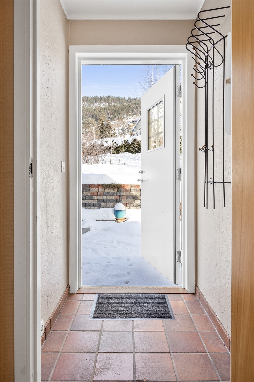 Entré med flislagt gulv. Inngangsdøren med glassfelt er fra 2015. Galleribilde