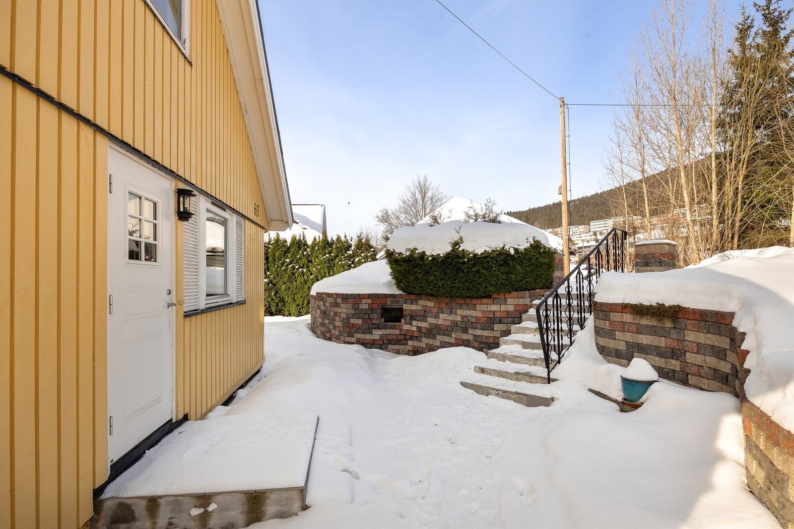 Tomten er opparbeidet med steinlagte uteplasser og solide forstøtningsmurer. Galleribilde