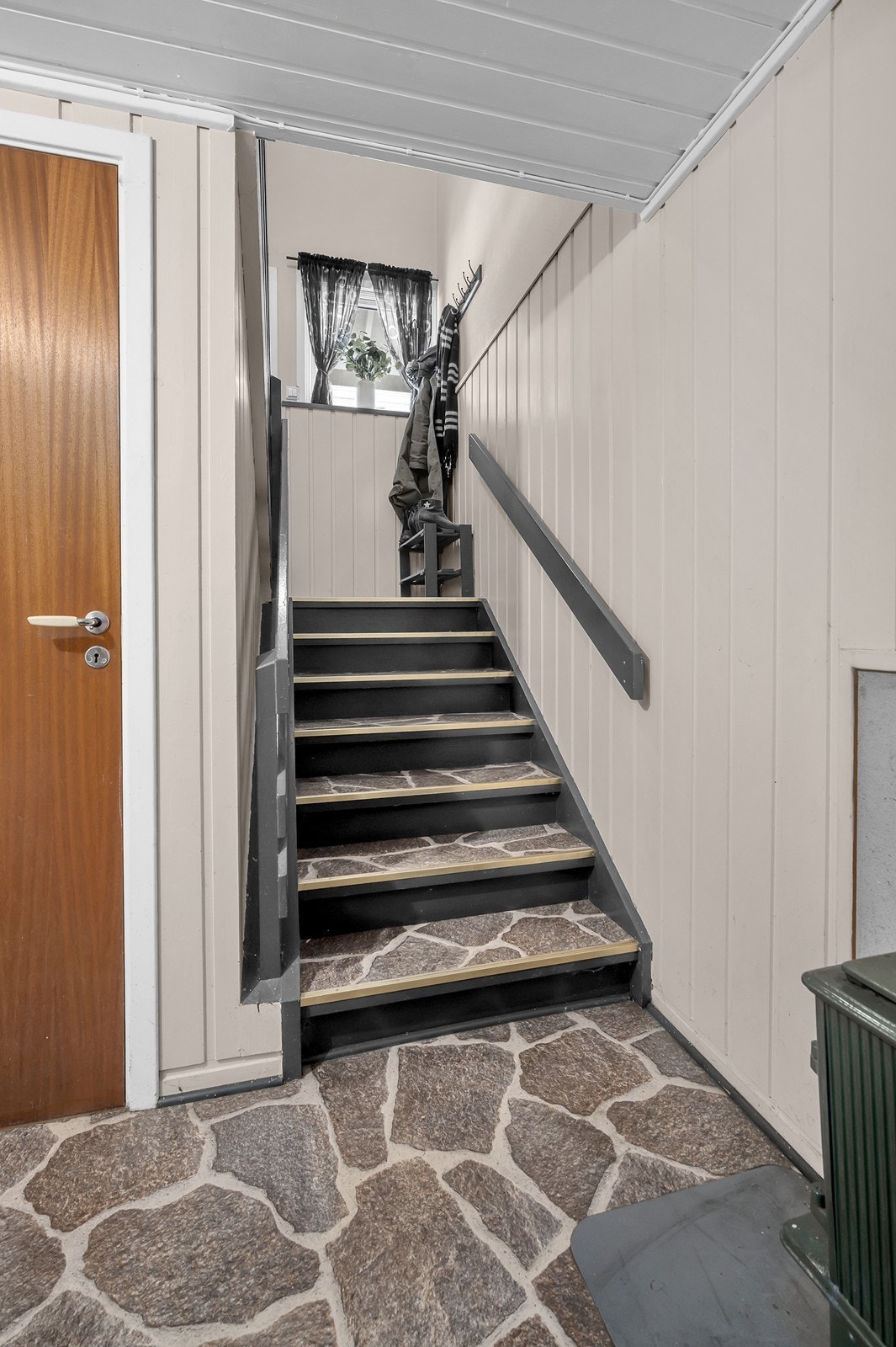 Fra gangen er det trapp opp til den andre inngangen og videre opp. Til venstre er det kott under trappen. Galleribilde