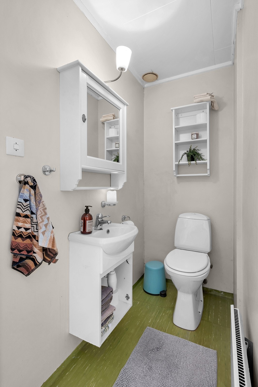 Toalettrommet har belegg på gulvet og vegger med tapet. Utstyrt med håndvask og toalett. Galleribilde