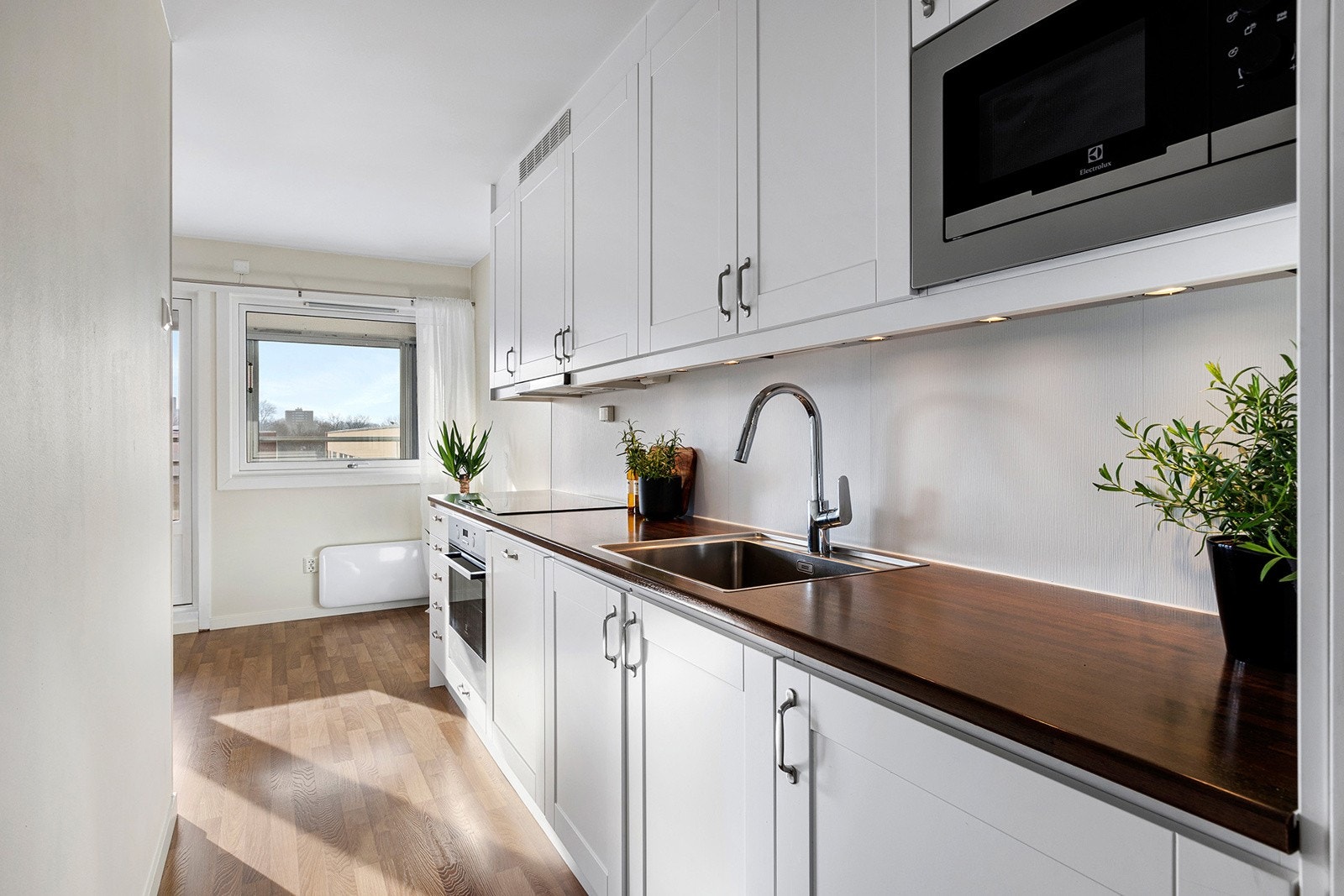 Kjøkken med profilerte fronter og integrerte hvitevarer som stekeovn, koketopp, oppvaskmaskin samt kjøl/ - fryseskap. Galleribilde