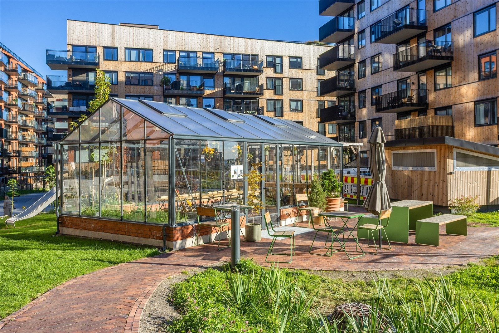 Borettslaget byr på et vakkert opparbeidet uteområde med drivhus og sosiale møteplasser. Galleribilde