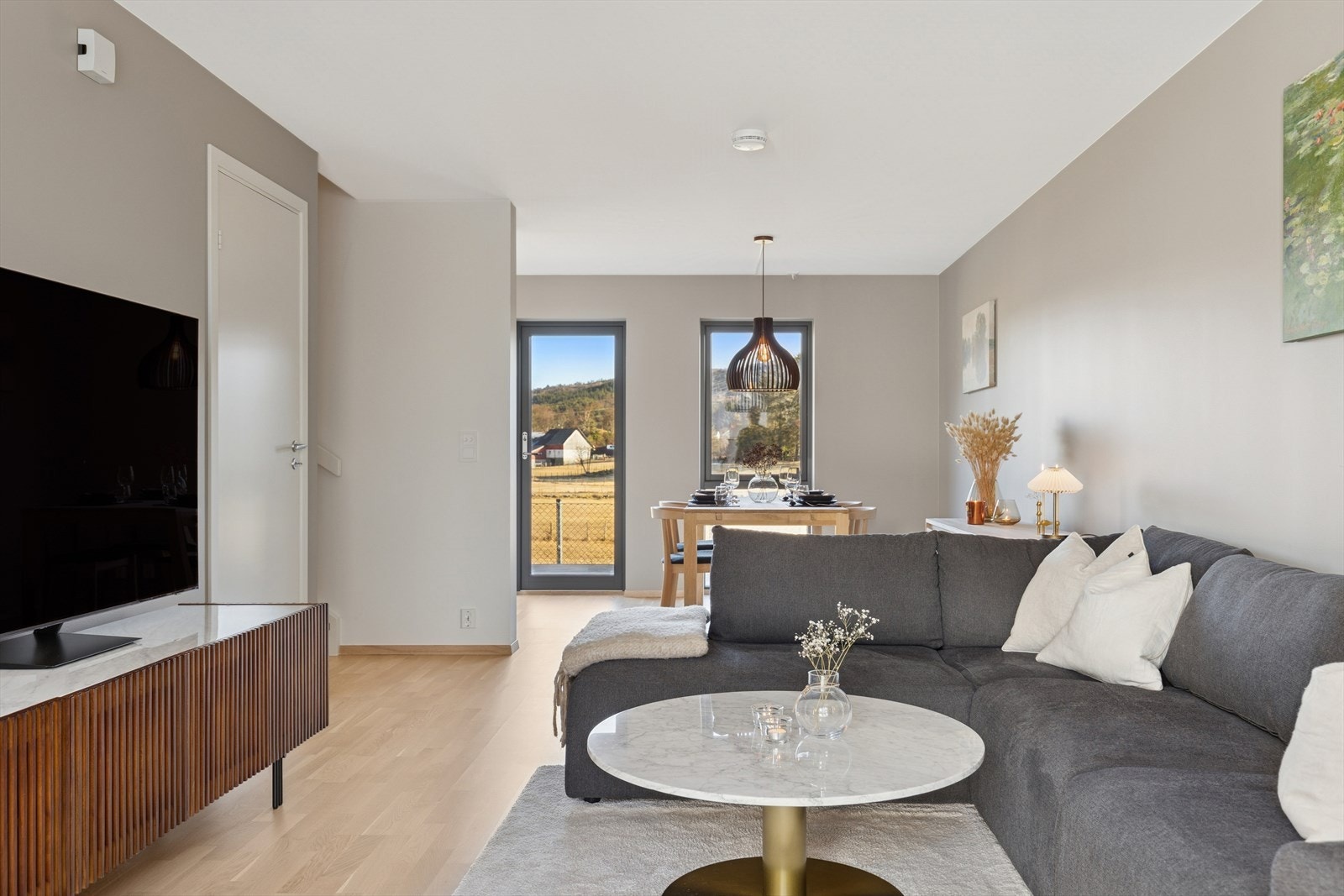 Den åpne løsningen mellom stue og spisestue skaper en sosial og fleksibel hovedetasje - med gode lysforhold og utsyn som gir rommet ekstra dybde. Galleribilde