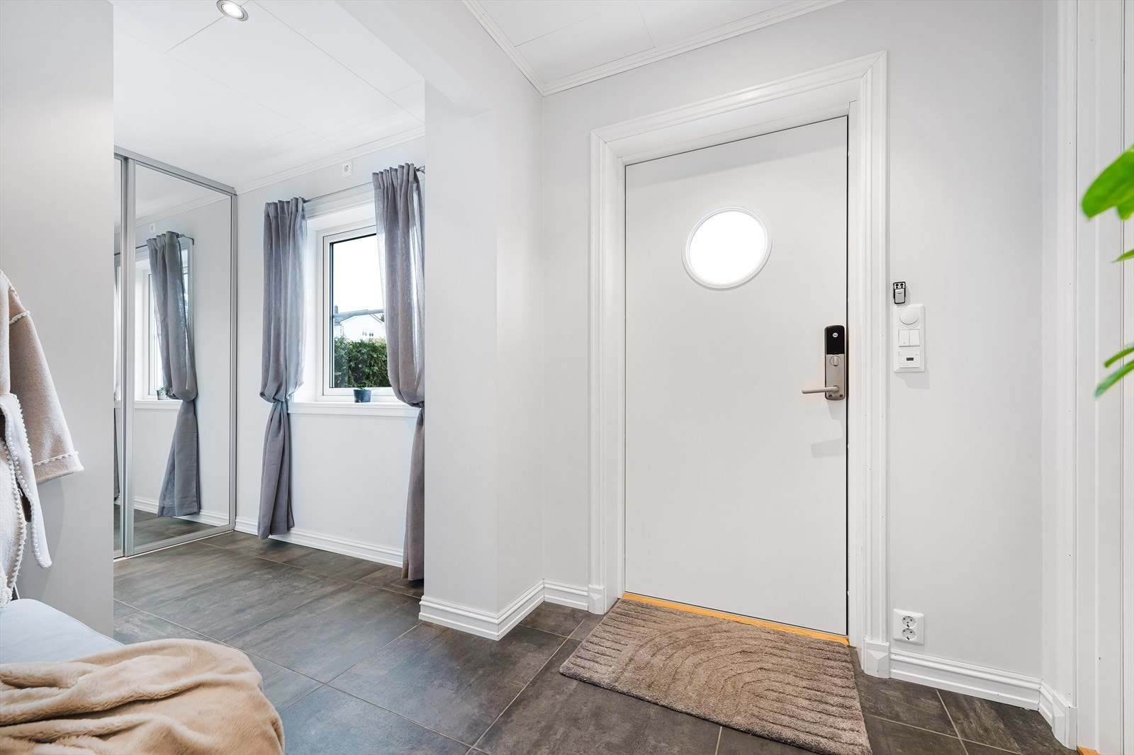 Entrè/vindfang med fliser på gulv og godt med garderobeskap for oppbevaring av yttertøy. Herfra er det direkte inngang til vaskerom. Galleribilde