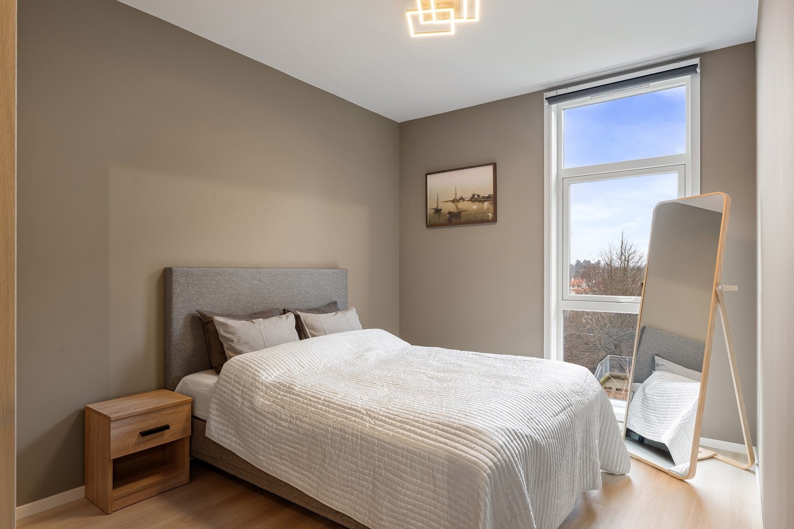 Hovedsoverommet har tidsriktige farger, er romslig, har god plass til dobbeltseng med nattbord på hver side, samt en moderne og stilfull taklampe Galleribilde