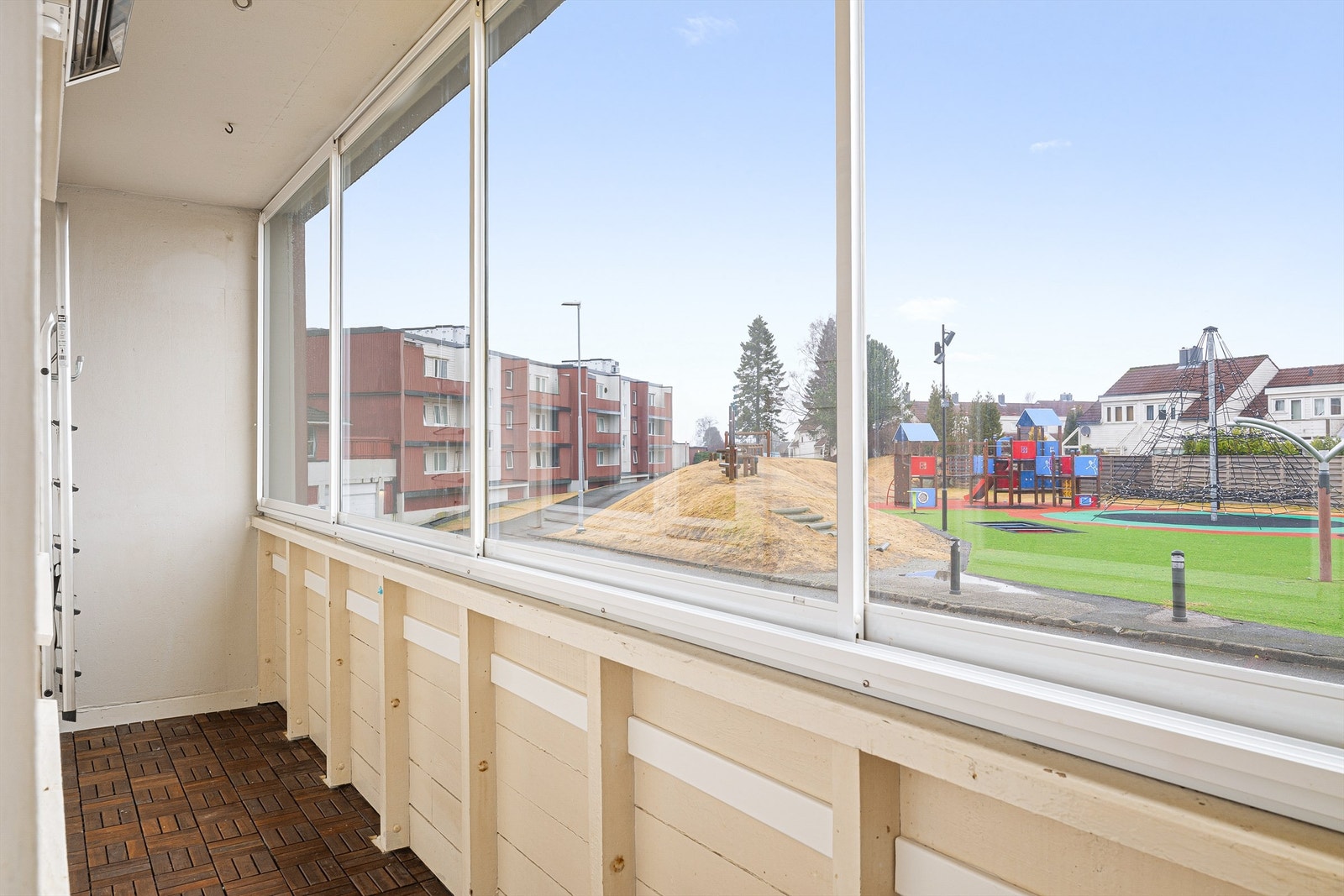 Balkongen er i en høy 1. etg., og utenfor ligger en hyggelig nyoppusset lekeplass Galleribilde