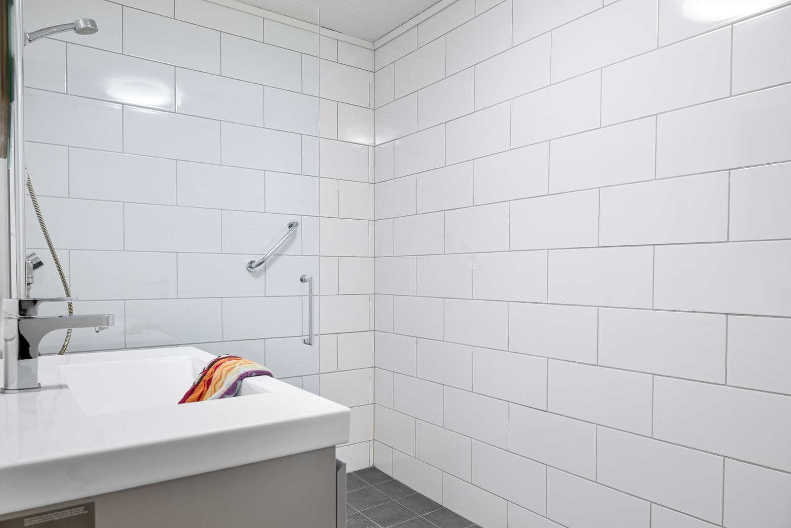 Her er det en romslig dusjnisje med glassvegg og en moderne baderomsinnredning Galleribilde