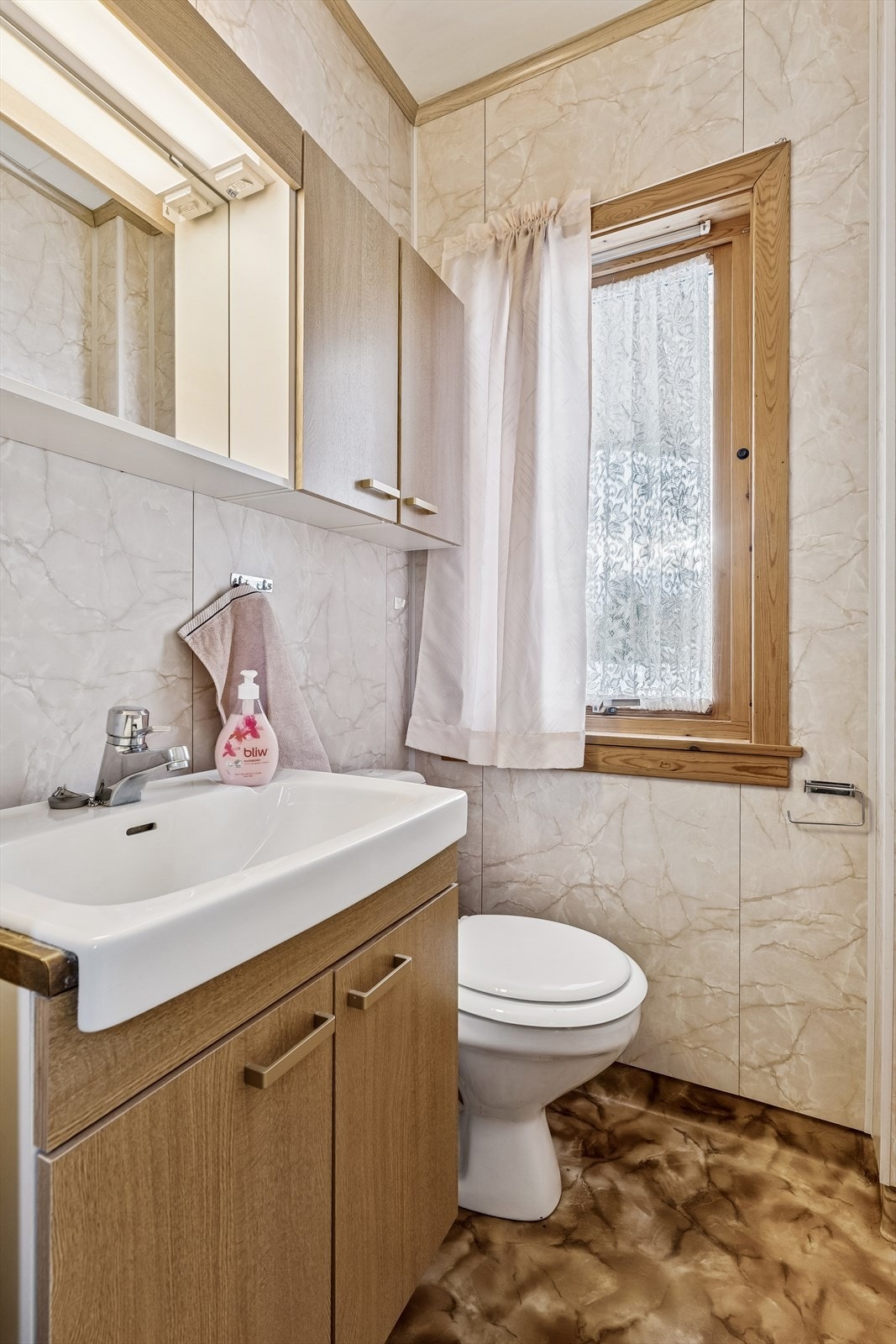 Separat toalettrom i første etasje med servant, overskap og speil med lys. Galleribilde