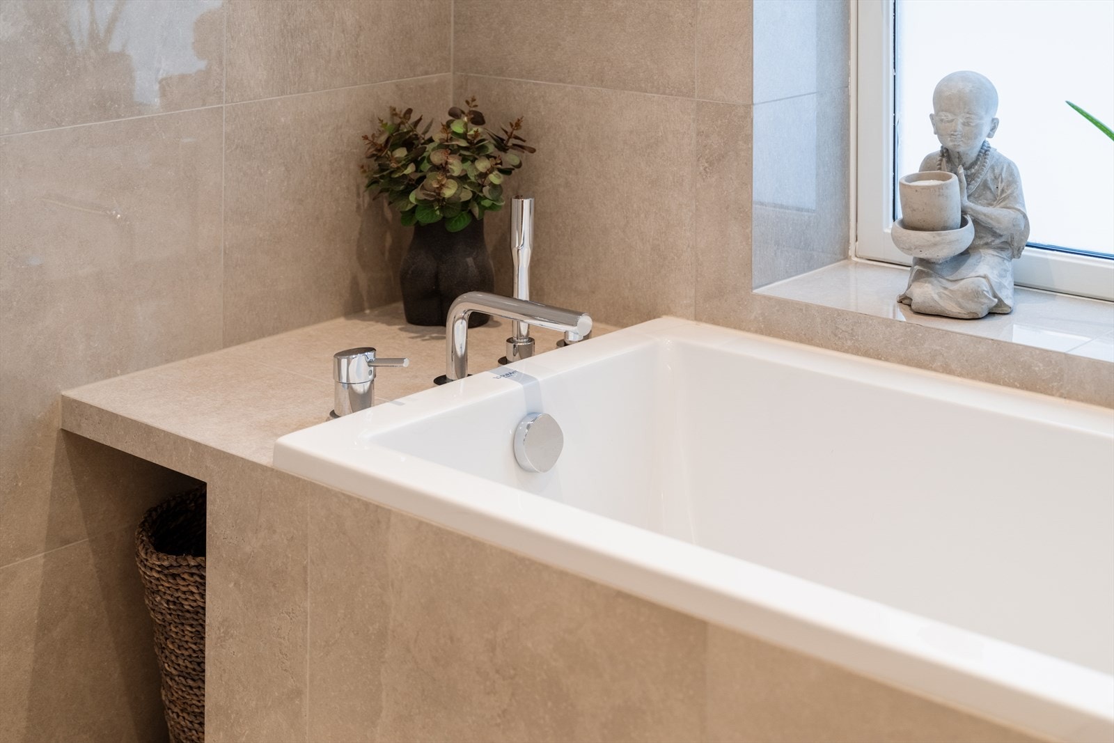 Hovedbadet er svært smakfullt med et innfliset badekar som understreker rommets helhetlige og eksklusive preg. Galleribilde