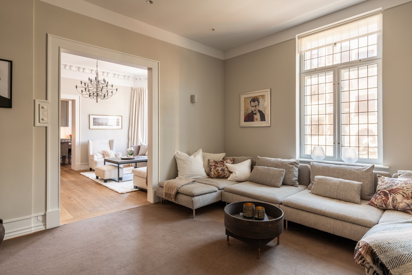 Den tilstøtende stuen fremstår som en mer tilbaketrukket og lun salong, ideell som TV-stue eller bibliotek. Galleribilde