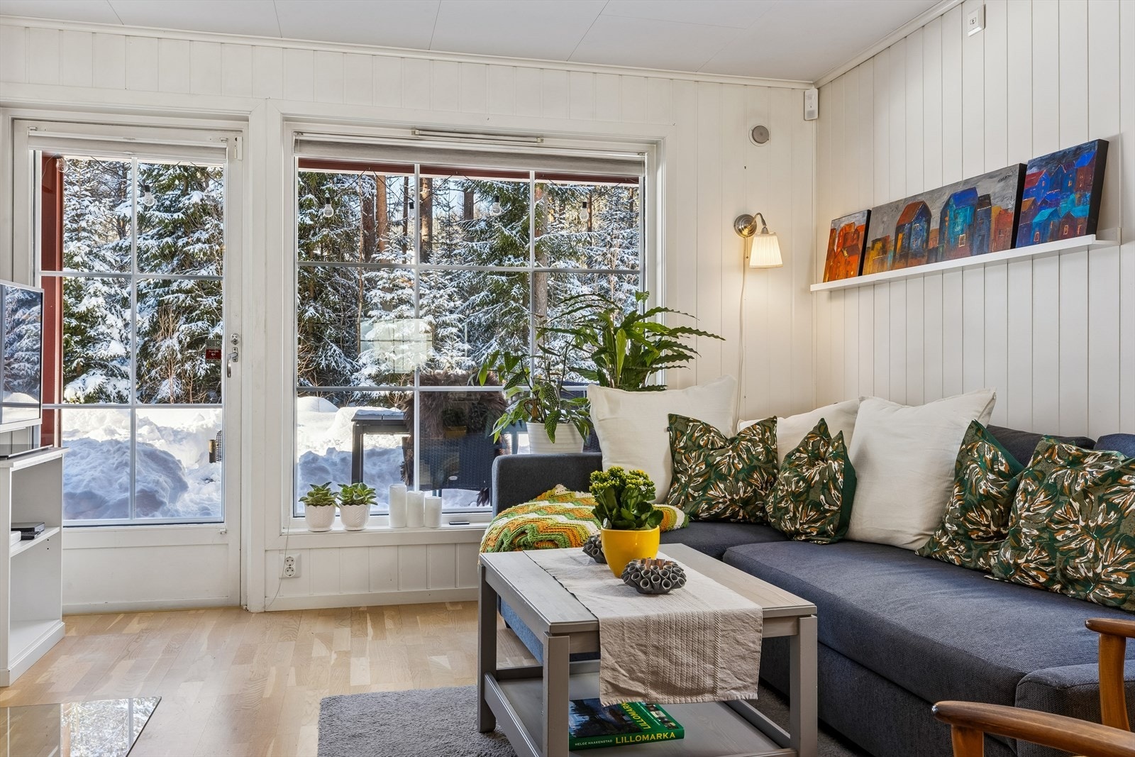 Fra de store vinduene strømmer dagslyset inn og gir en vakker innramming av skogen utenfor Galleribilde