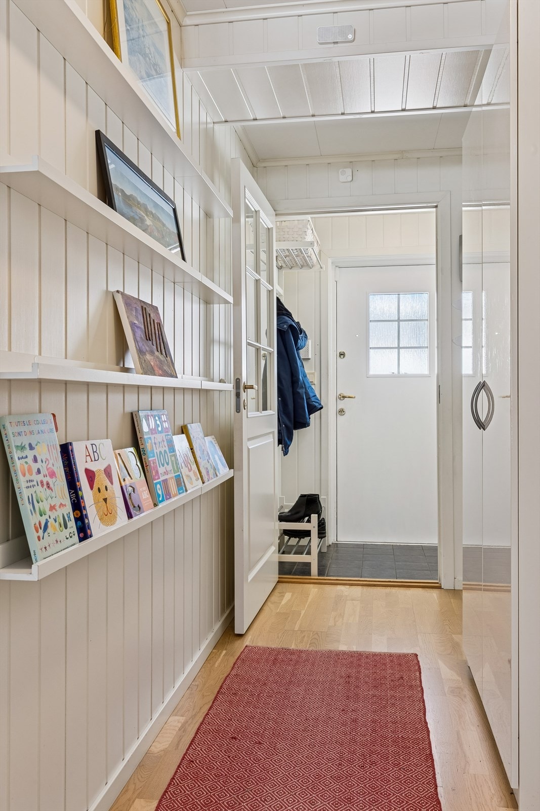 Velkommen inn i en gang med flislagt gulv i vindfanget og adkomst videre til boligens øvrige rom Galleribilde