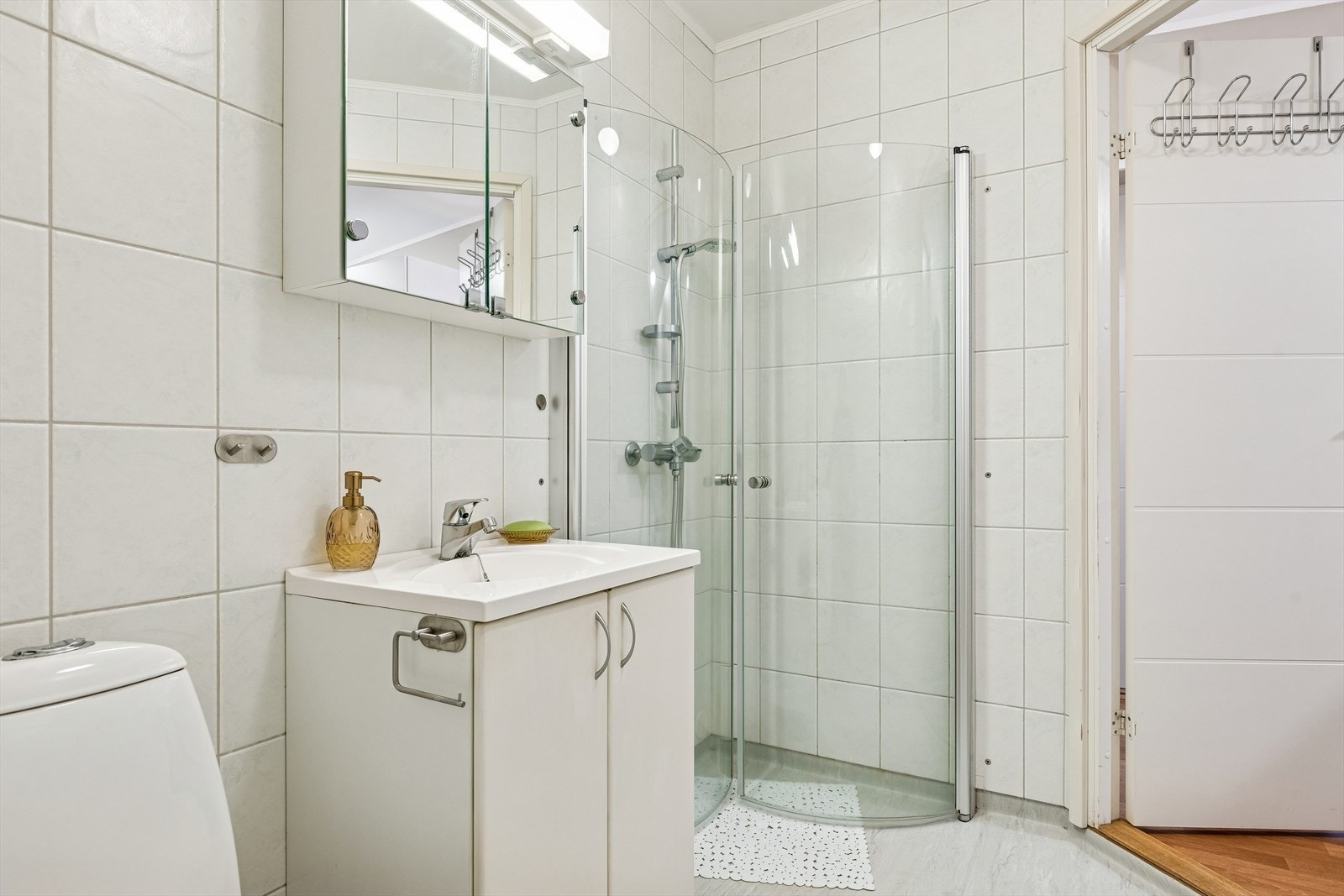 Innredningen består av en heldekkende porselensvask og overskap med speildører. Galleribilde