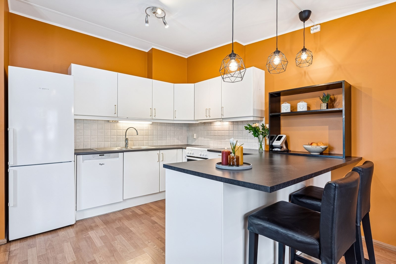 Kjøkkeninnredningen har slette, lakkerte fronter og en slitesterk laminatbenkeplate. Galleribilde