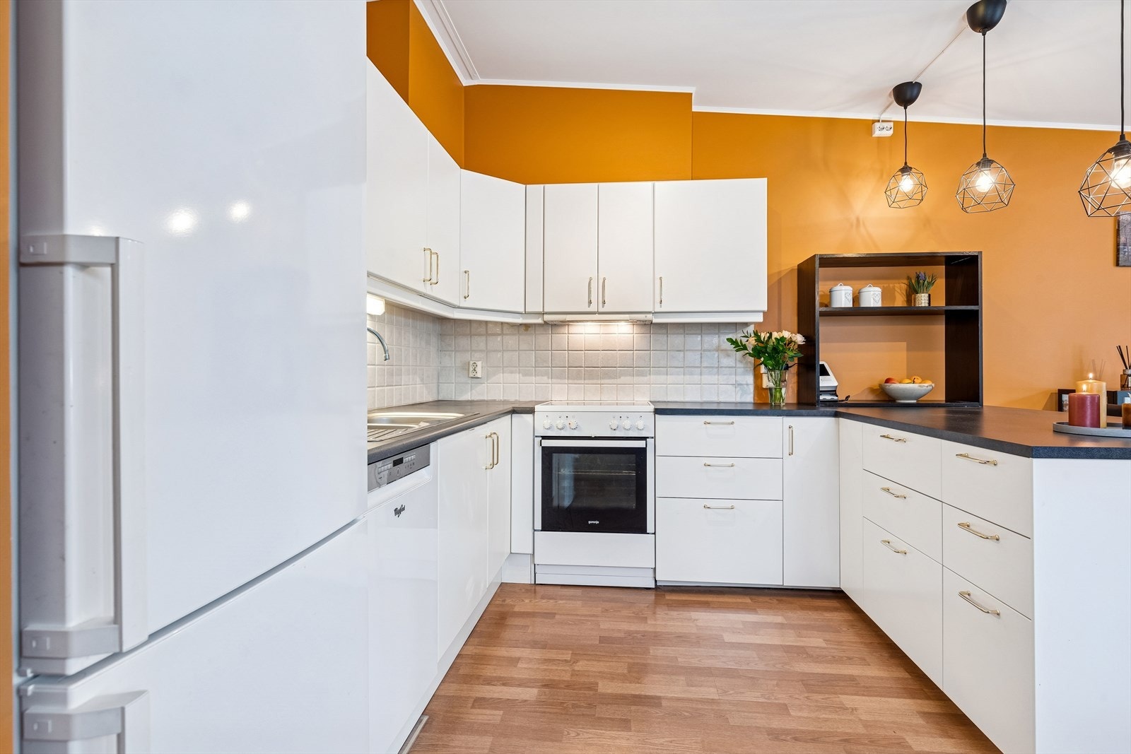 Kjøkkenet er utstyrt med frittstående komfyr, oppvaskmaskin og kjøleskap. Galleribilde