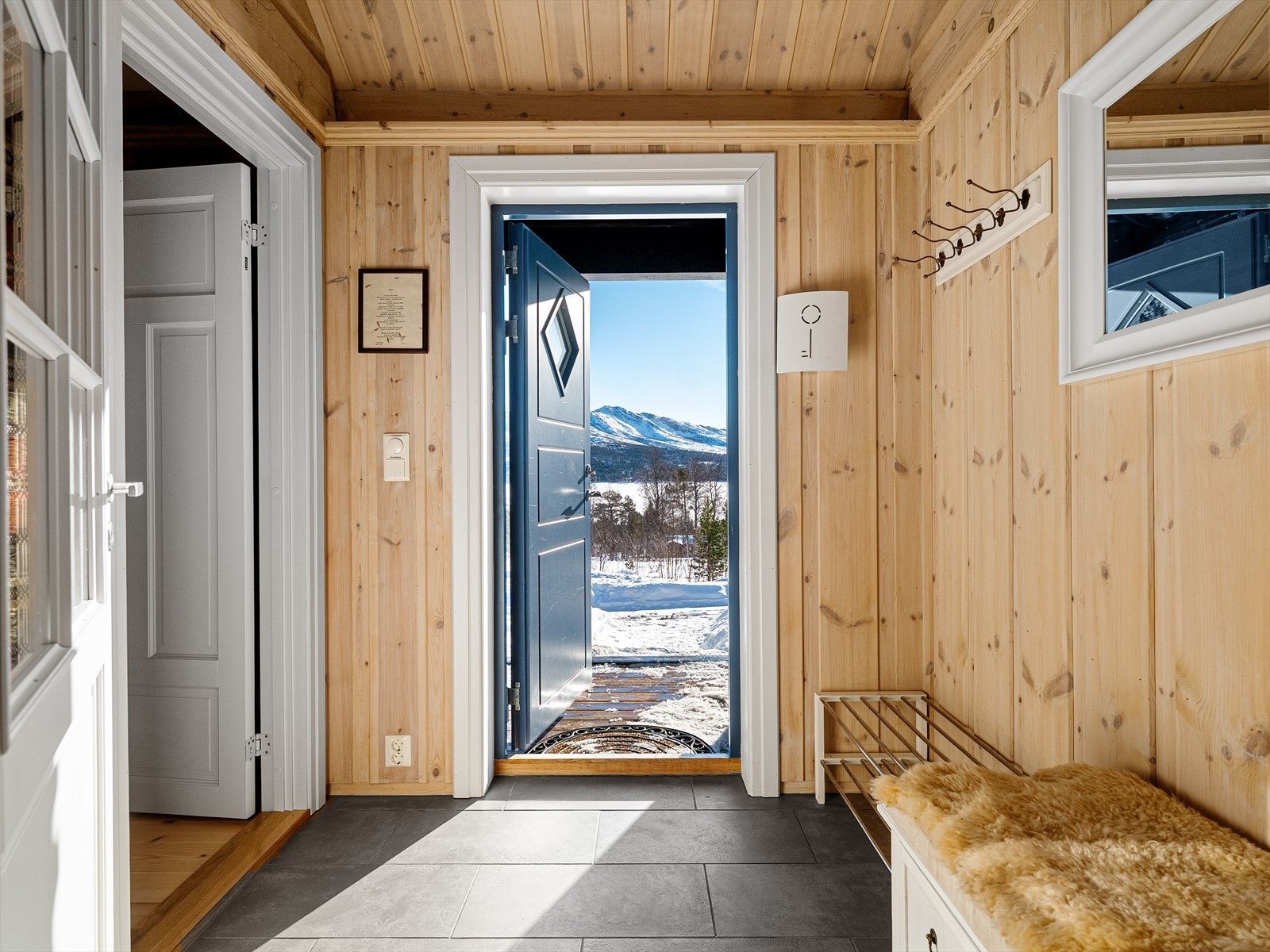 Når man kommer inn i hytta blir man møtt av en koselig entré på 3,5 kvm med varme i gulv. Her har du god plass til oppbevaring av sko og yttertøy. Det ble skiftet termostat i 2026. Galleribilde