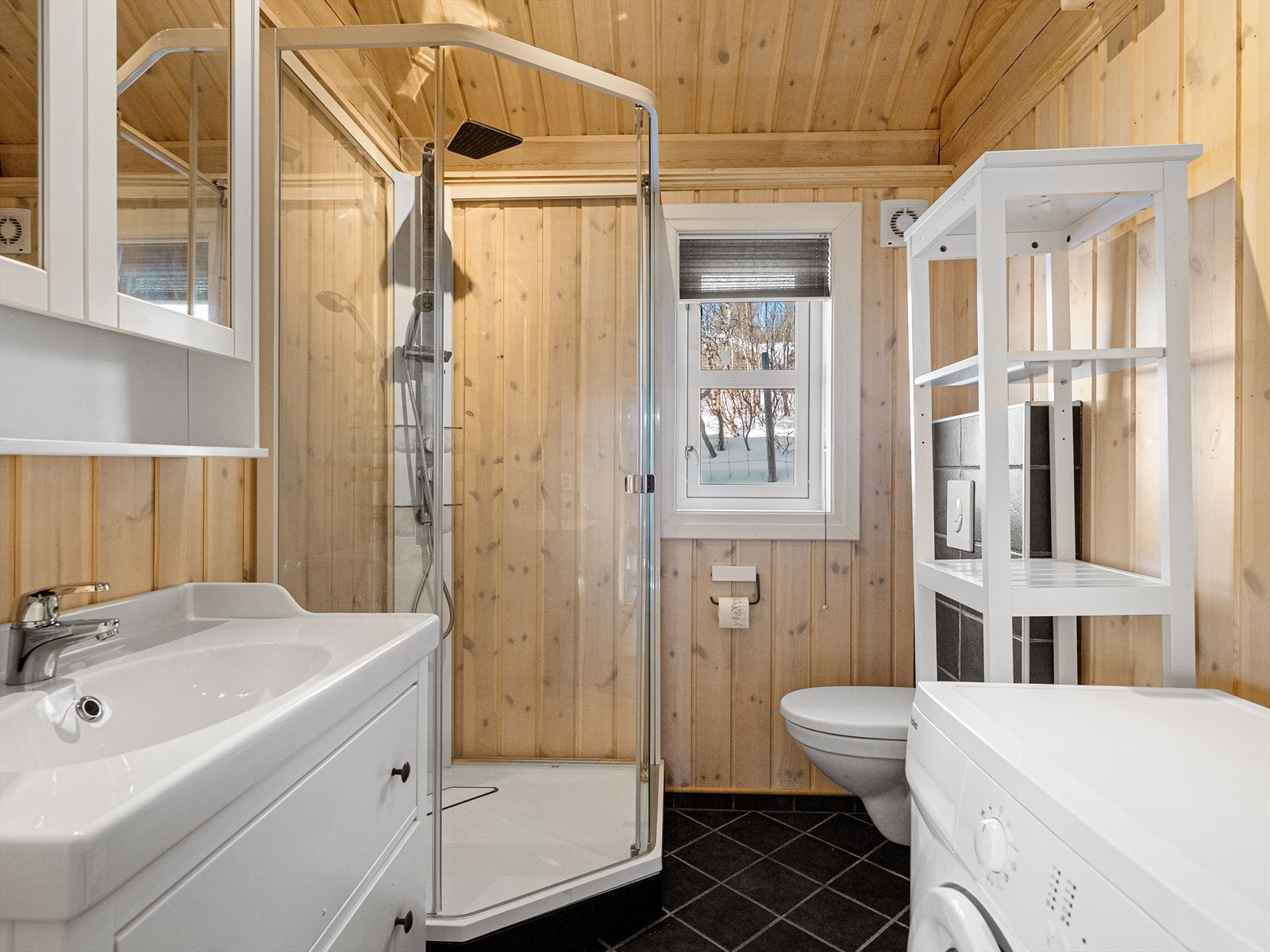 Baderom utstyrt med enkel servant, vegghengt klosett og eget dusjkabinett. Galleribilde