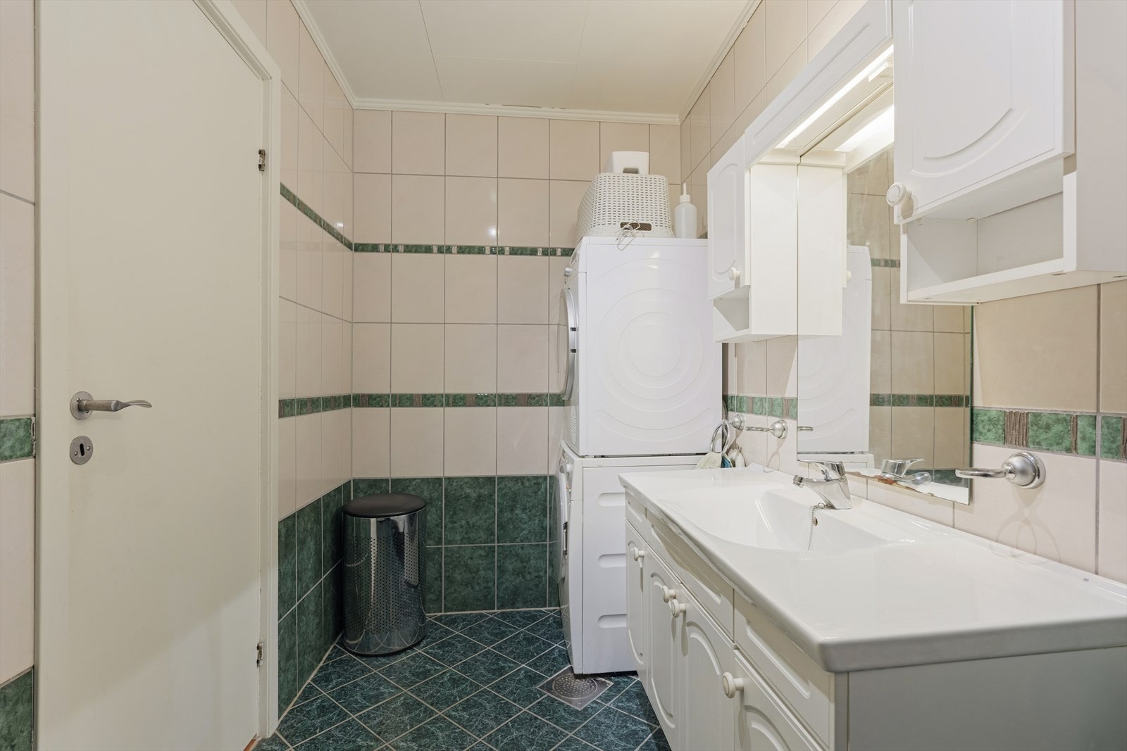 Badet har innredning med nedfelt servant, dusjkabinett og opplegg for vaskemaskin Galleribilde