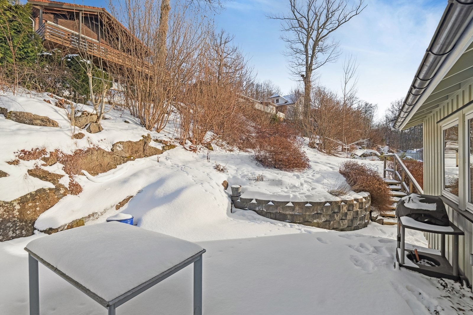 Uteområdet er pent opparbeidet med blomsterbed og beplanting Galleribilde