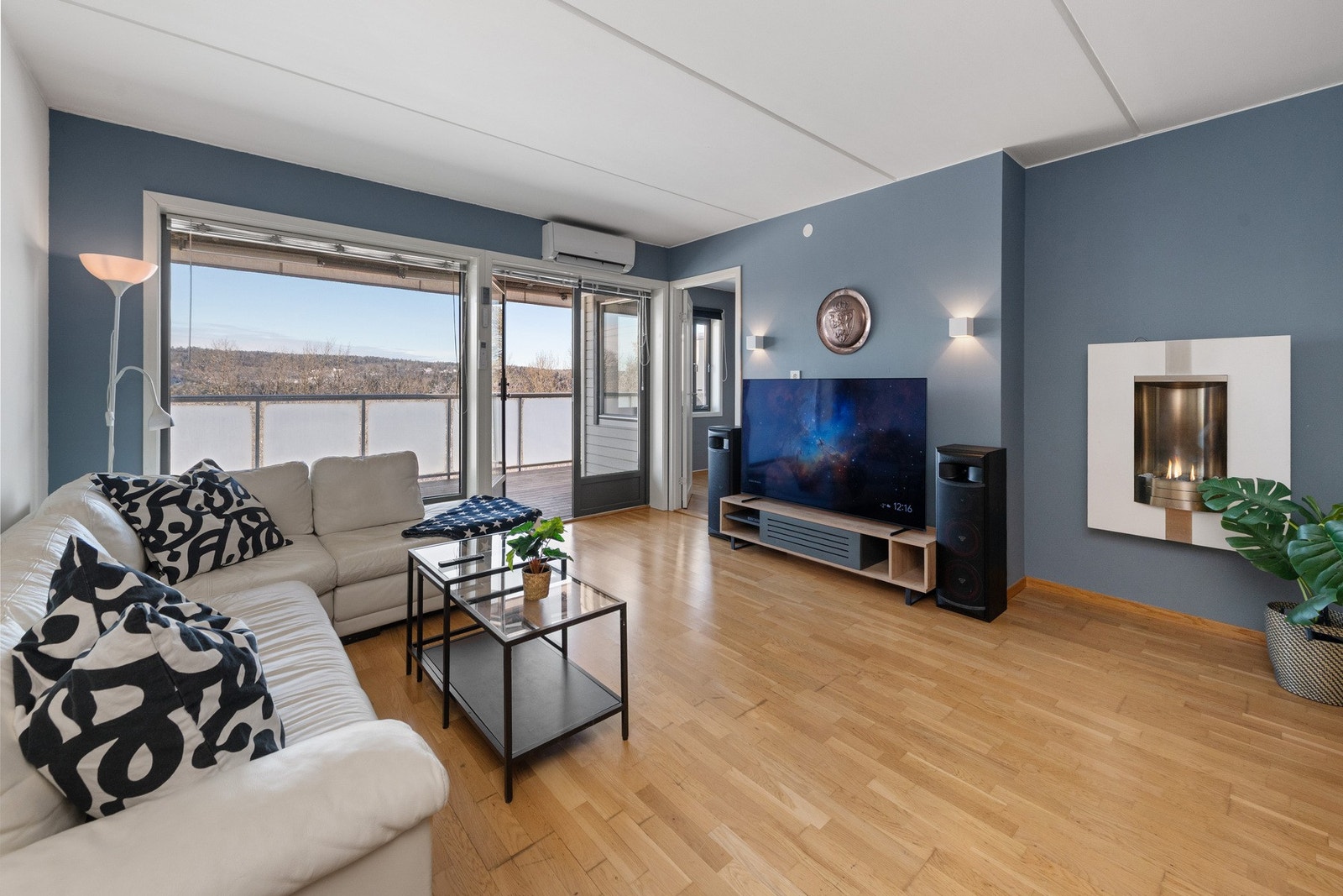 Stor og luftig stue med parkett på gulv og malte vegger Galleribilde