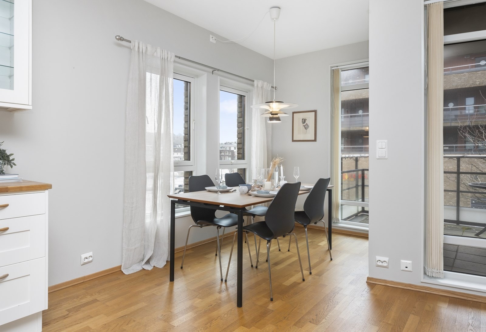 Spiseplassen er plassert i enden av kjøkkenet, med rikelig lys fra flere store vinduer Galleribilde