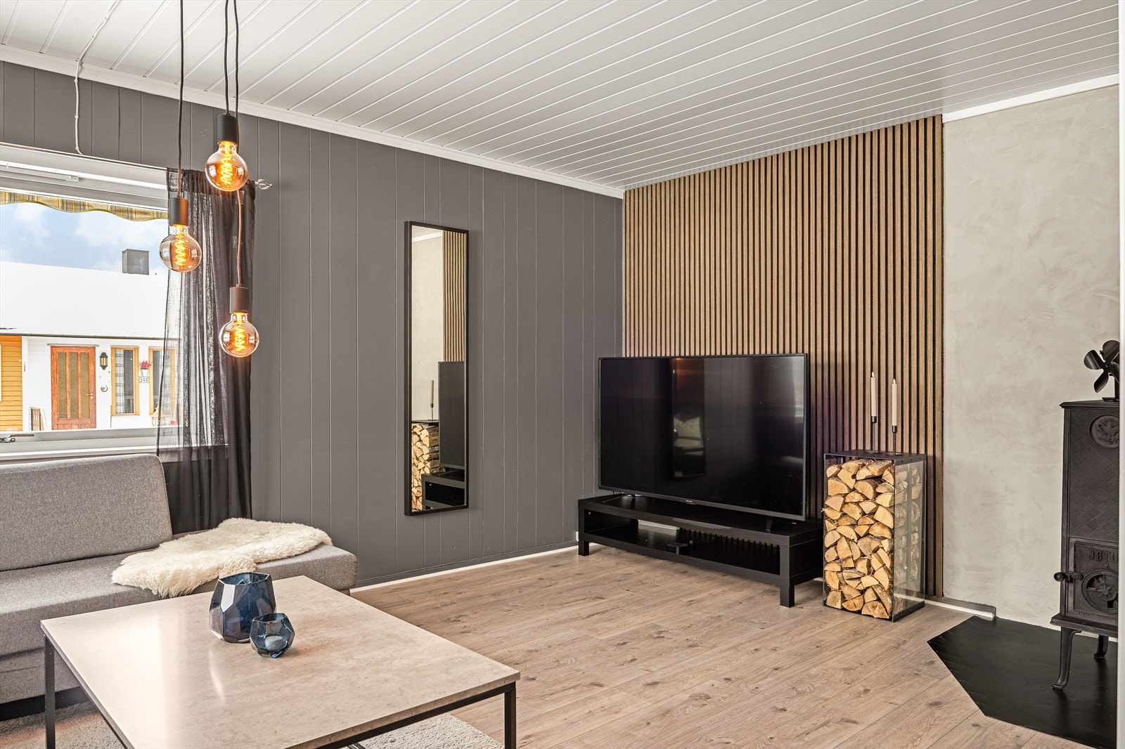 Spilekledning på veggen bak TV-en og vedovn i hjørnet. Galleribilde