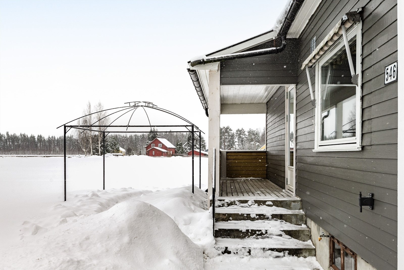 Overbygget veranda med på pilarer av betong og med betongtrapp. Galleribilde