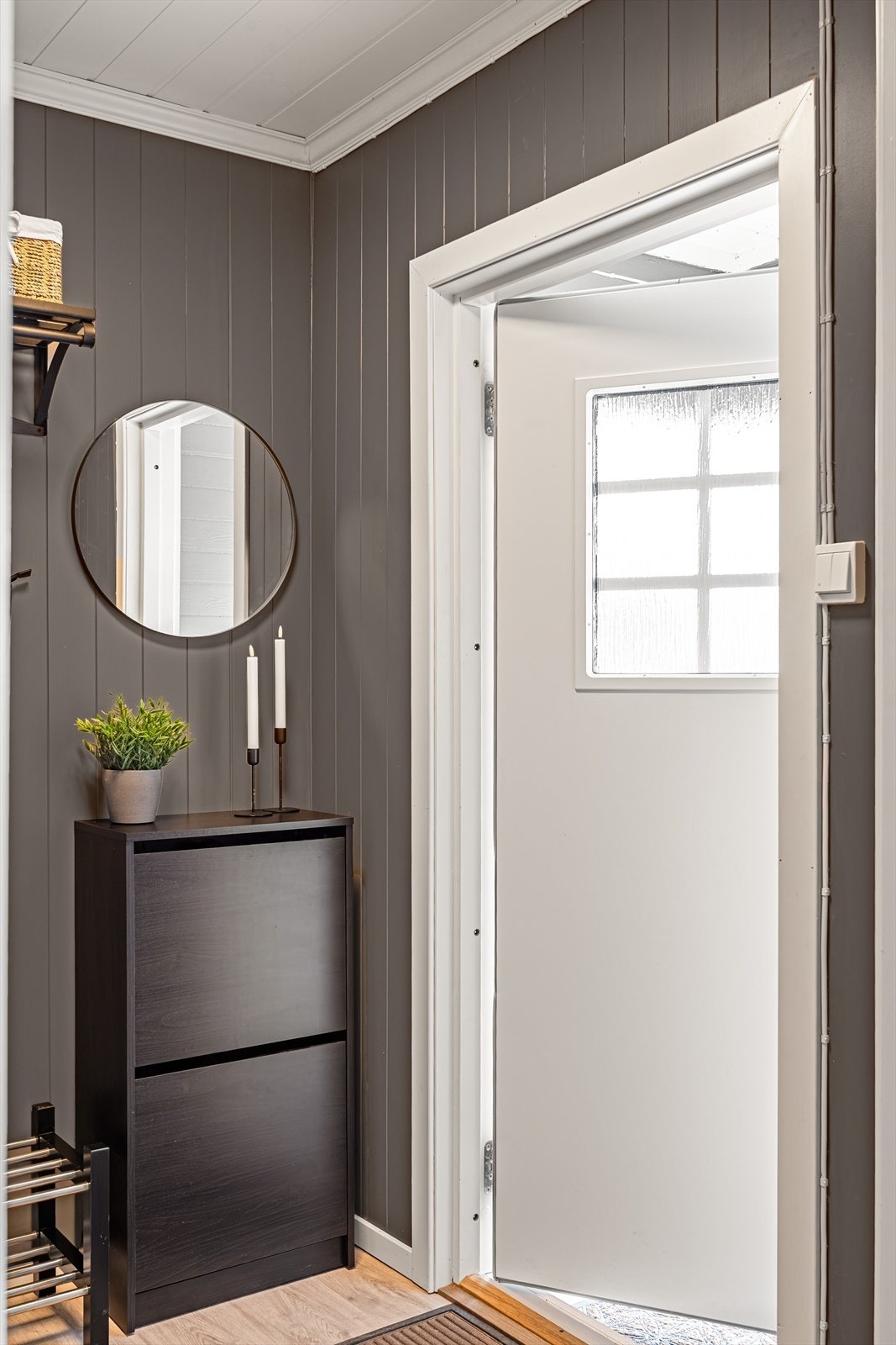 Entréen har panelte vegger malt i en lun gråfarge og lyst laminatgulv. Galleribilde