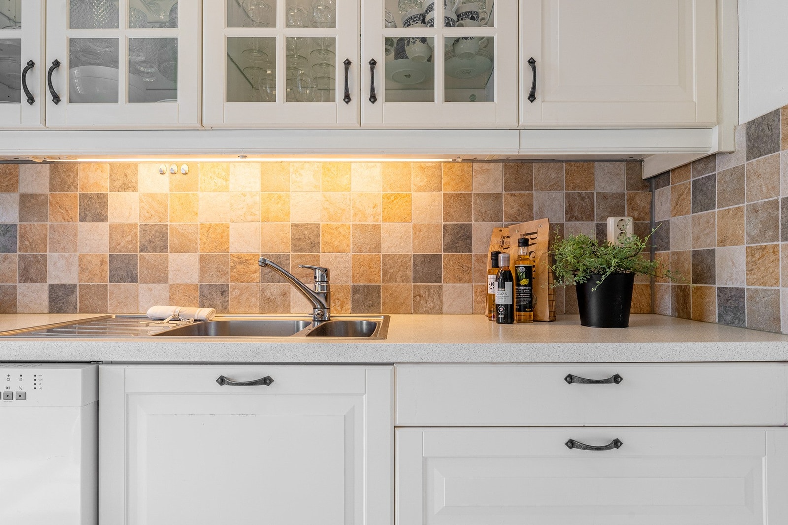 - To av overskapene har glassfronter, det er laminat benkeplate og delikate fliser mellom benkeplaten og skap - Galleribilde