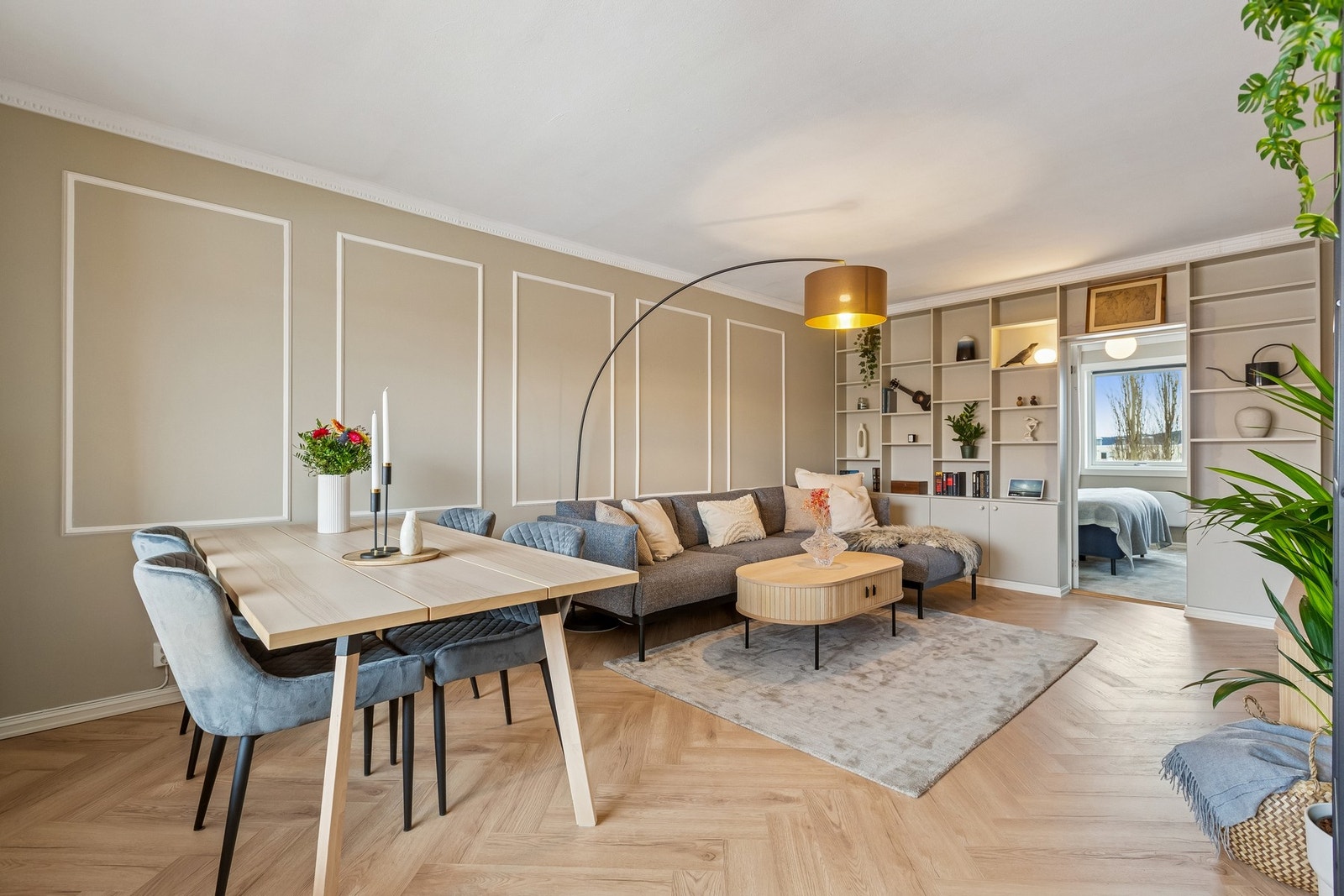 Her er det valgt et moderne uttrykk med fiskebenslaminat, plassbygd bokhylle og pyntelister på vegg. Galleribilde