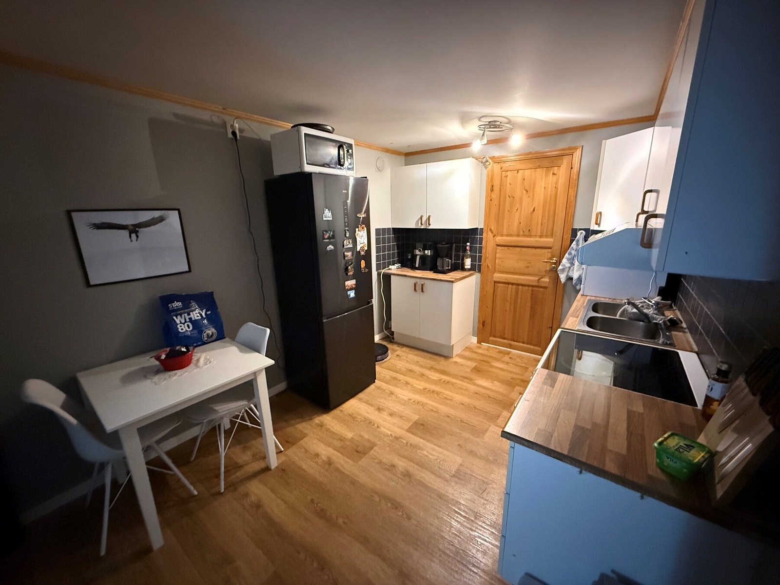 Kjøkken med lys innredning og laminat benkeplate. Galleribilde