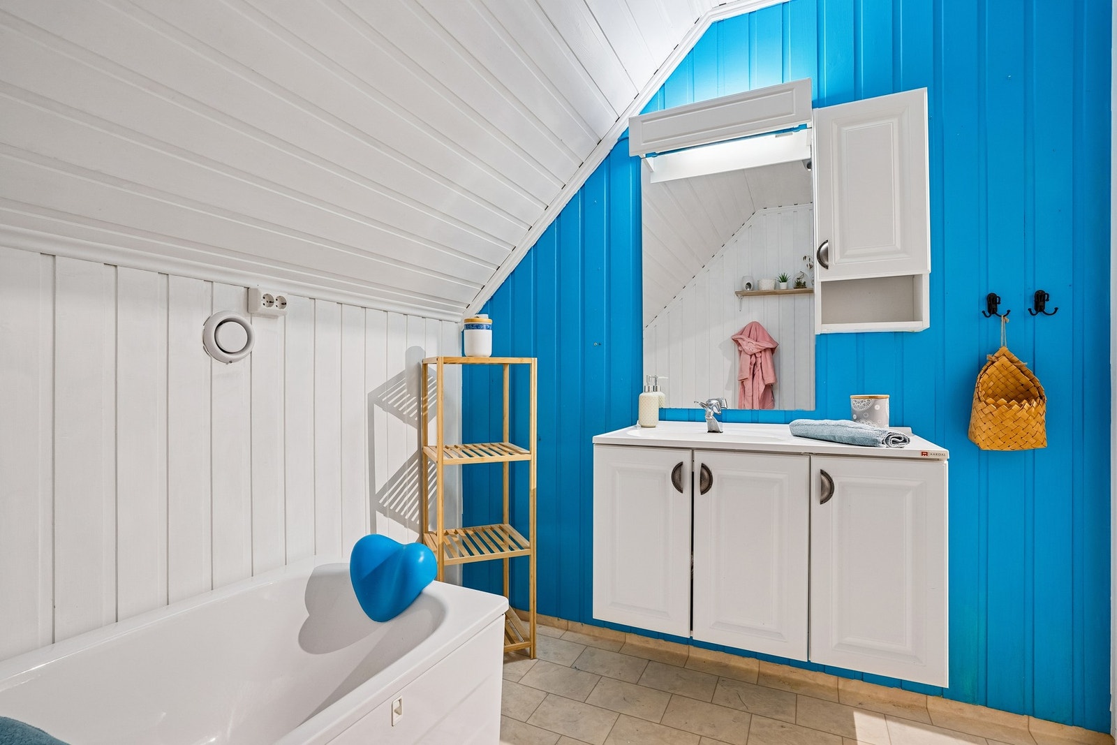 Bad på loft med toalett, badekar og vask og baderomsinnredning. Galleribilde