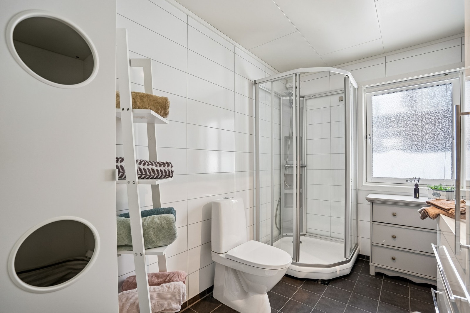 Bad/vaskerom i hovedetasje har fliser på gulvet og våtromsplater på vegger. Galleribilde